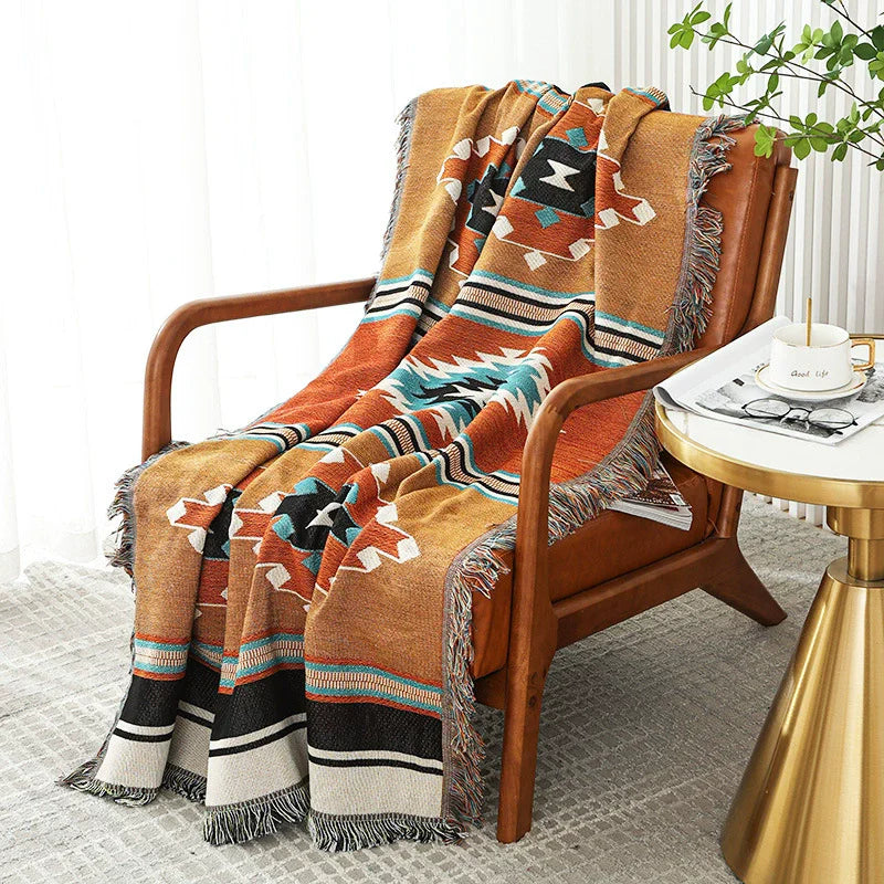 Rustic Terracotta Aztec throw blanket on a wooden armchair beside a gold side table