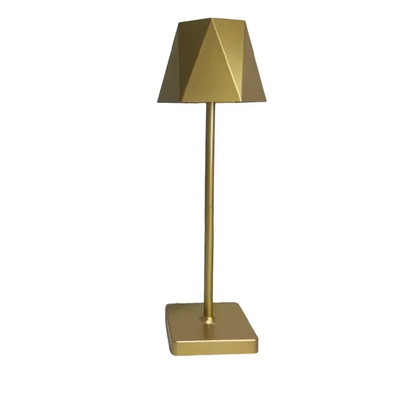A copper table lamp with a geometric shade on a white background