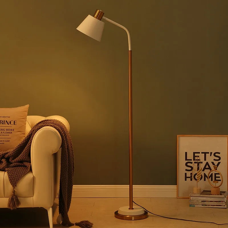 White arc floor lamp glowing warmly against a green wall