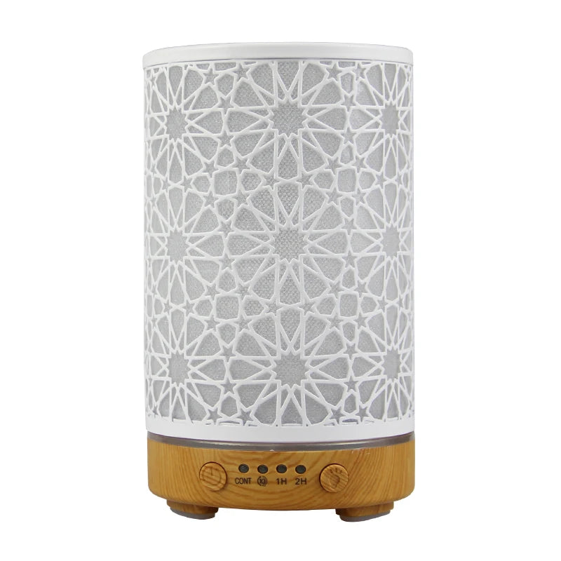 Star pattern essential oil diffuser with white exterior and light wood grain base showing control buttons.