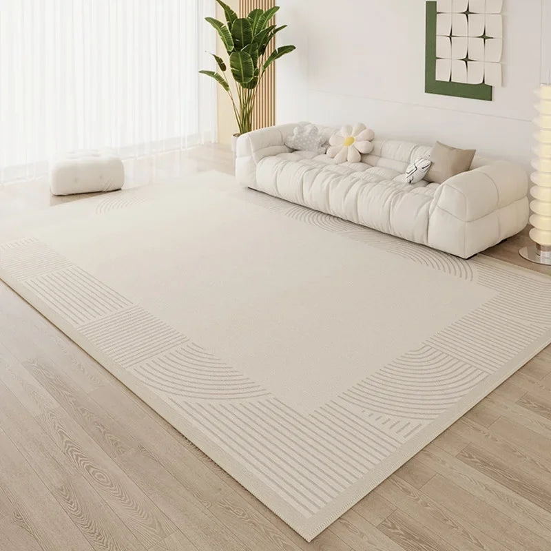 Large cream area rug with tonal arc corner border detail in a bright minimalist living room with white cloud sofa