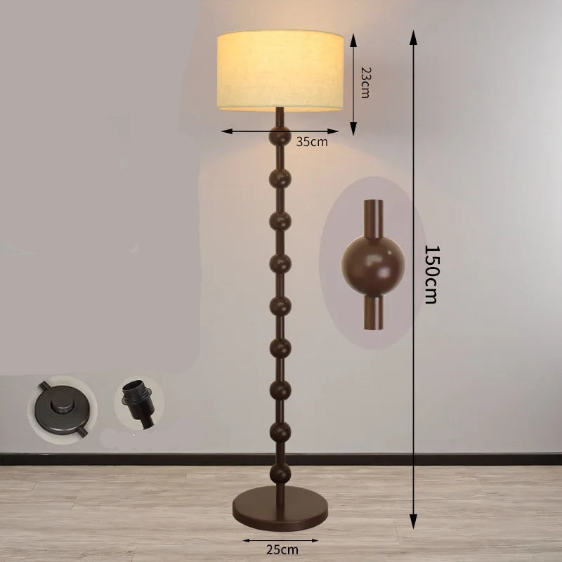 Minimalist floor lamp at 150cm height with a brown wood stem and integrated foot switch.