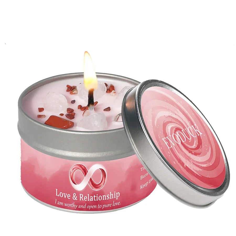Pink 'Love & Relationship' candle in a tin with a lit wick on a white background