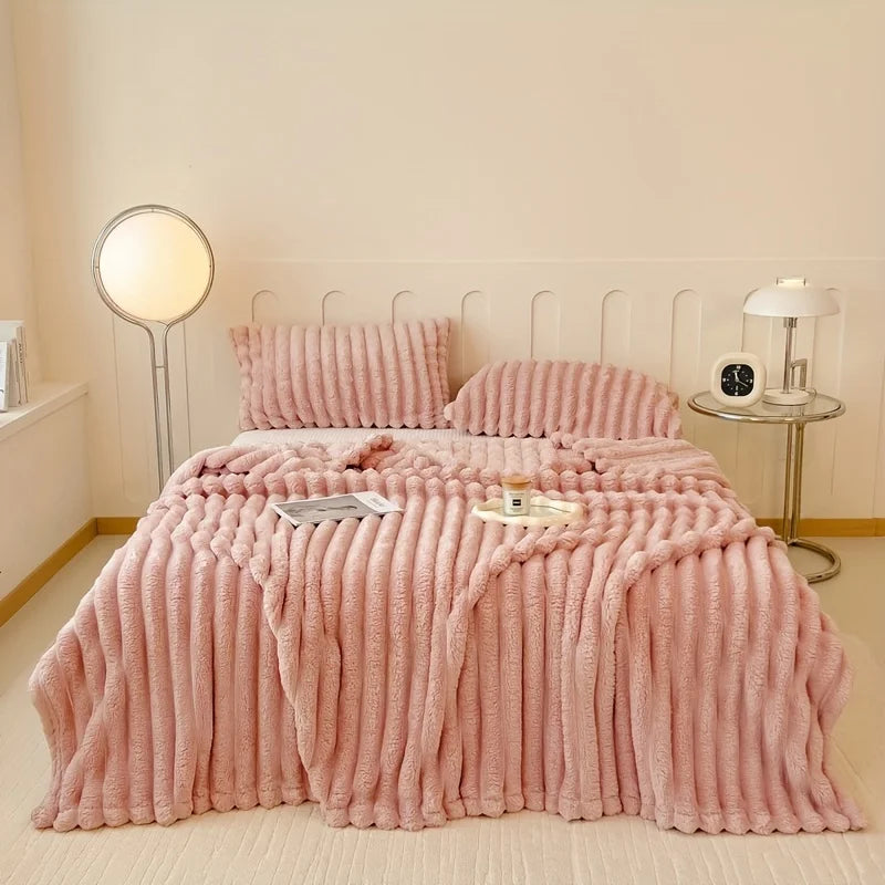 Pink textured bedspread set on a bed in a bedroom with lamps and nightstands.