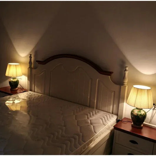 Bedroom with a bed, wooden headboard, and two lamps on nightstands.
