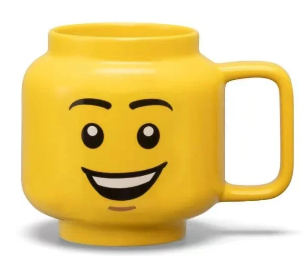 Yellow mug with a smiling face design on a white background