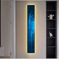 Modern interior with a vertical light panel displaying a blue abstract design.