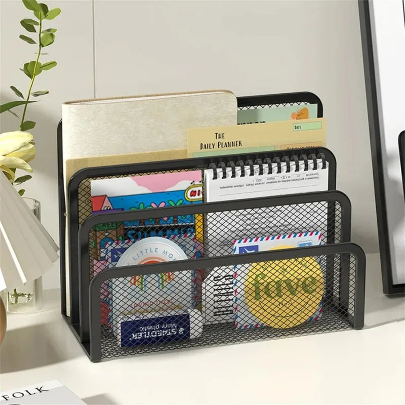 Black mesh desk organizer with various items on a white surface