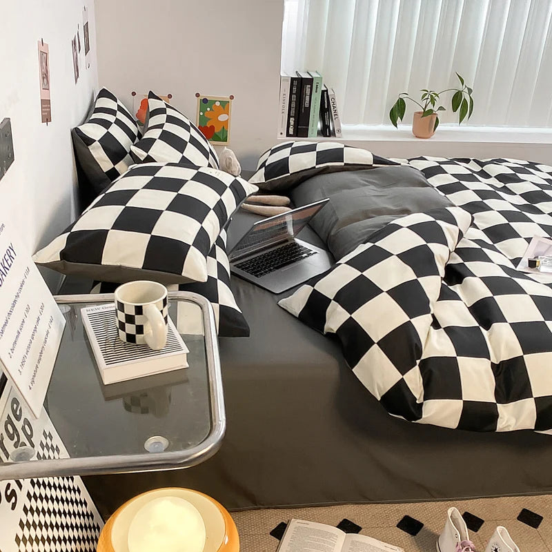 Black and white checkerboard duvet cover set with matching pillowcases dressed on a double bed in a modern styled bedroom