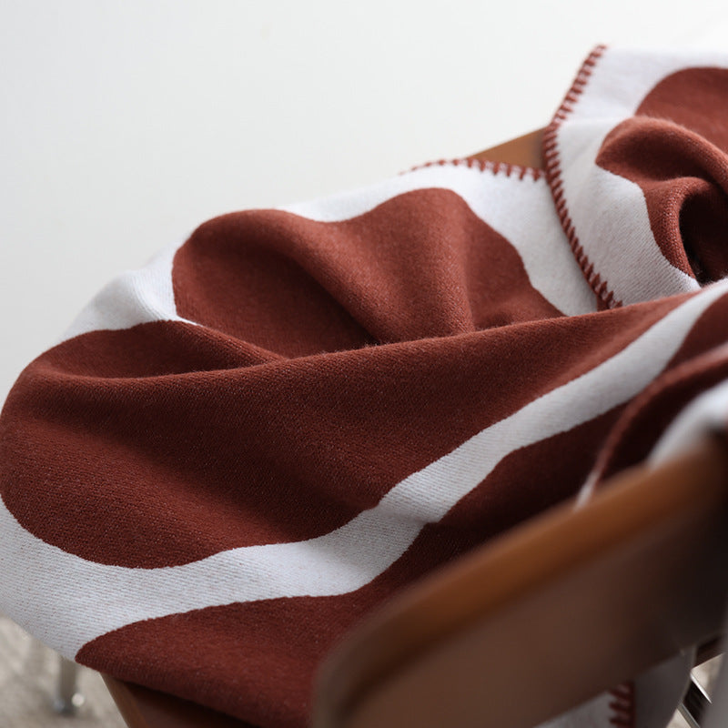 Rust and cream abstract jacquard blanket close-up.