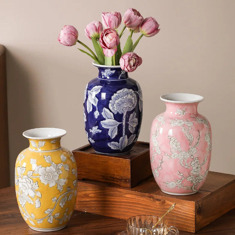 Three decorative vases with floral patterns on a wooden surface.