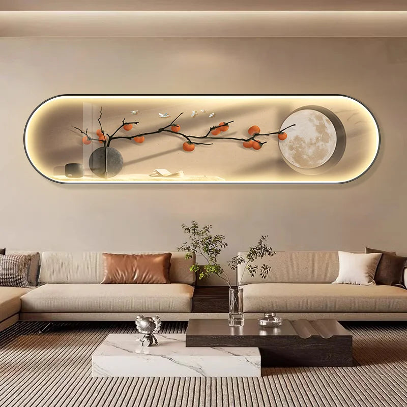 Long oval wall art piece with a built-in LED backlight, depicting a serene still life of persimmons and a moon phase, styled in a luxury modern living room with marble furniture.