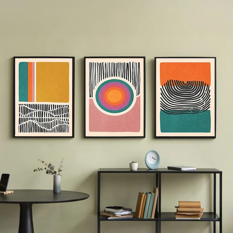 Three abstract canvas prints in mustard, orange, teal and pink with bold line art details