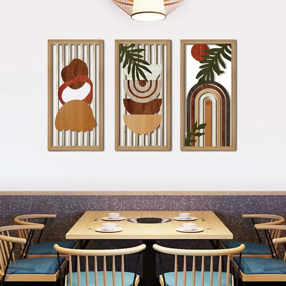 Three abstract wall art pieces on a wall above a dining table with chairs.
