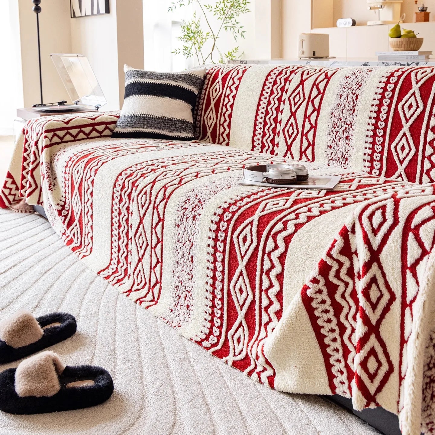 A textured jacquard sofa cover with red and cream geometric tribal diamond patterns.