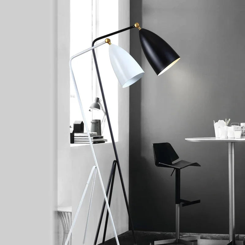 Modern floor lamp with black-and-white shades in a minimalist room.