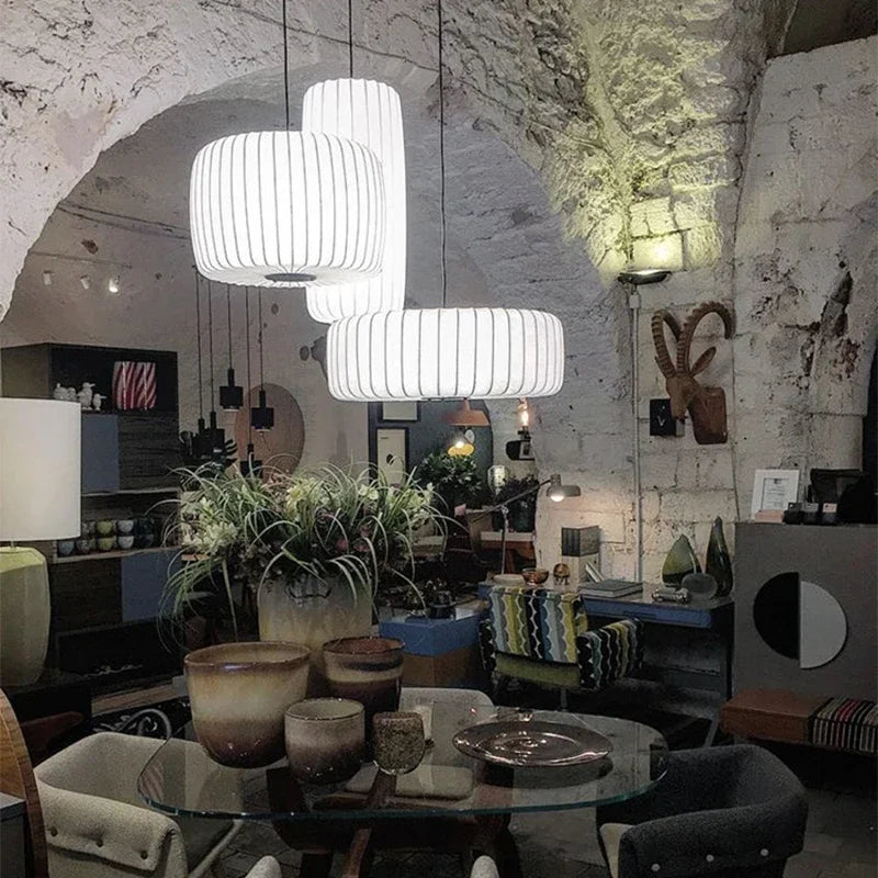 Modern interior design with pendant lights, table, chairs, and decorative items.