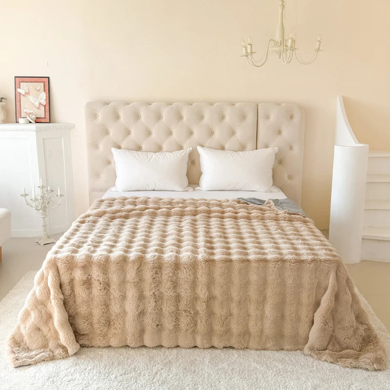 Beige textured blanket on a bed in a bedroom setting