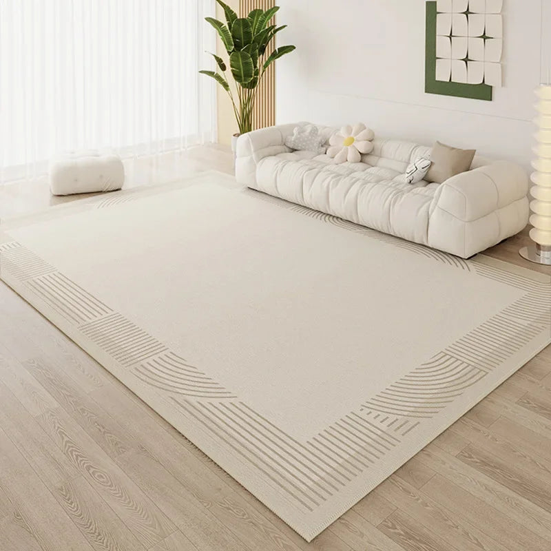 Large cream area rug with subtle tonal corner line border in a bright minimalist living room with white cloud sofa
