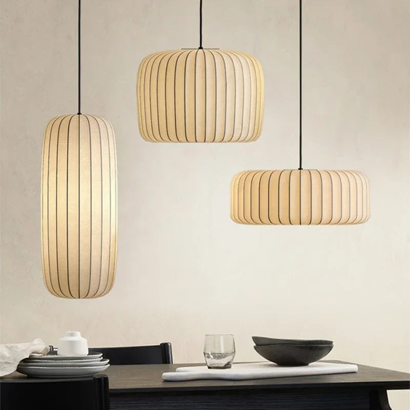 Three pendant lights hanging above a dining table with a neutral background