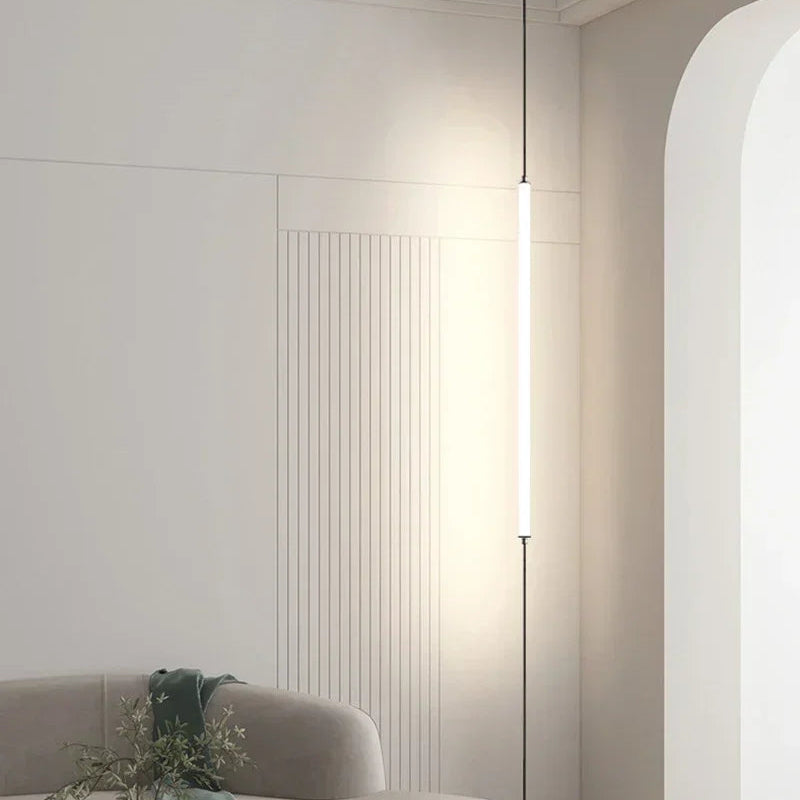 Minimalist vertical LED floor lamps installed from ceiling to floor in a modern interior