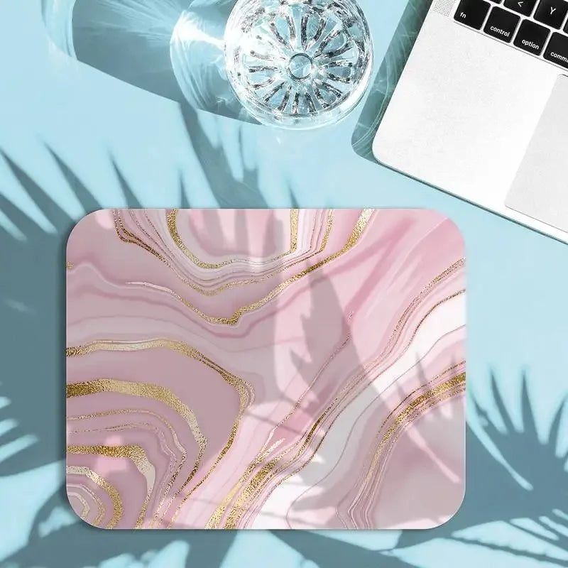Pink marble mouse pad with gold accents on a light blue surface
