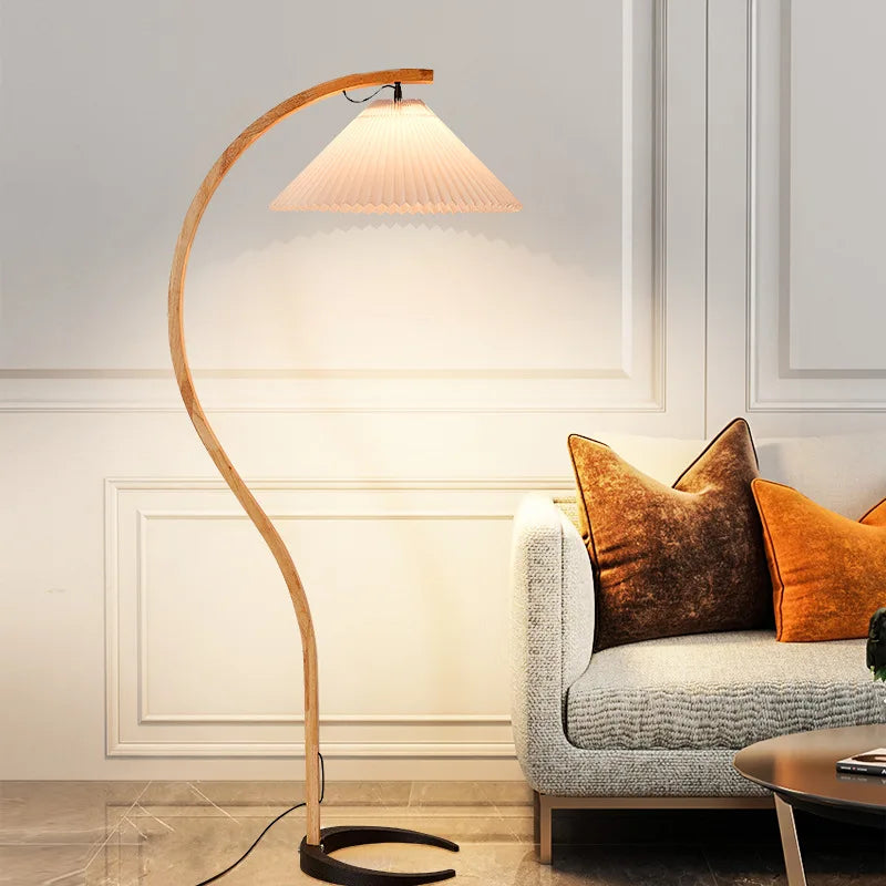 Floor lamp next to a sofa with decorative pillows in a living room setting.
