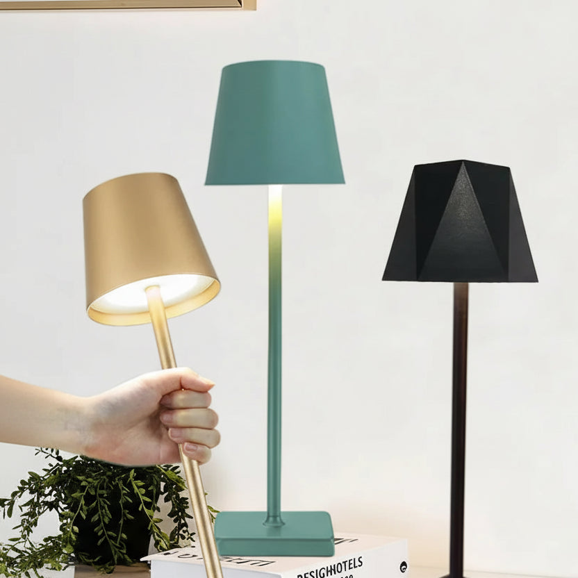 Four table lamps with different colored shades on a desk, showcasing a 3-colour step dimming feature.