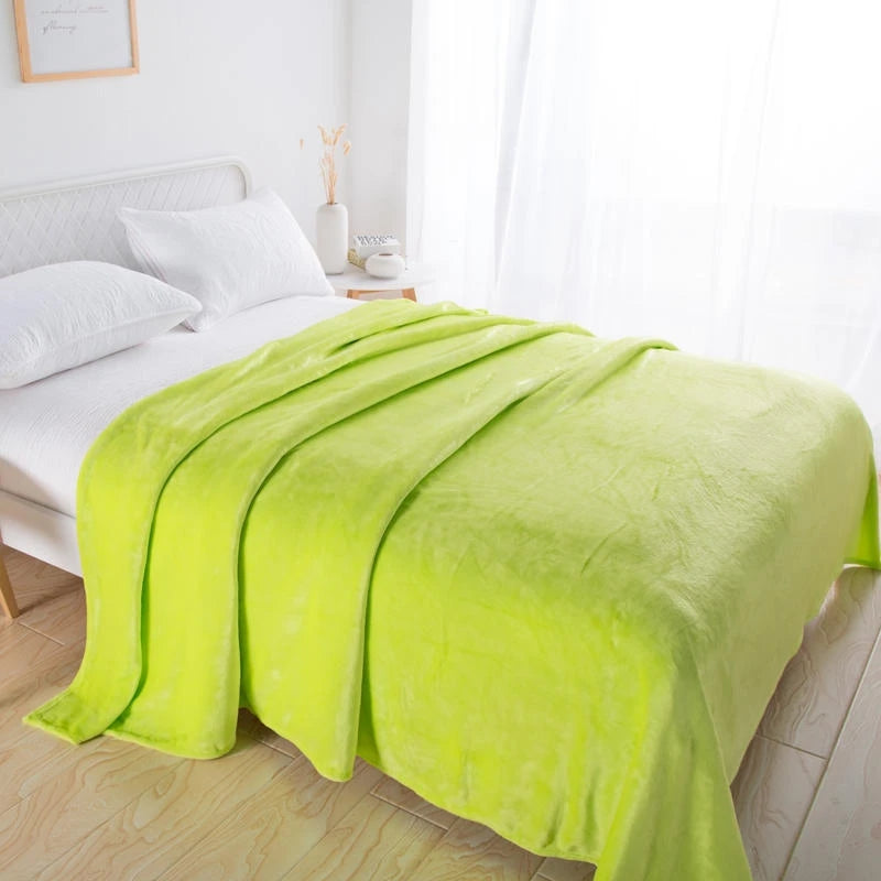 Lime green plush blanket folded back across a white bed