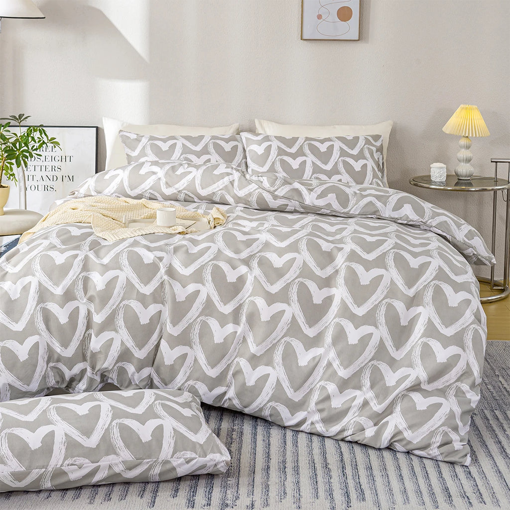 Gray and white heart-patterned bedding set on a bed in a bedroom.