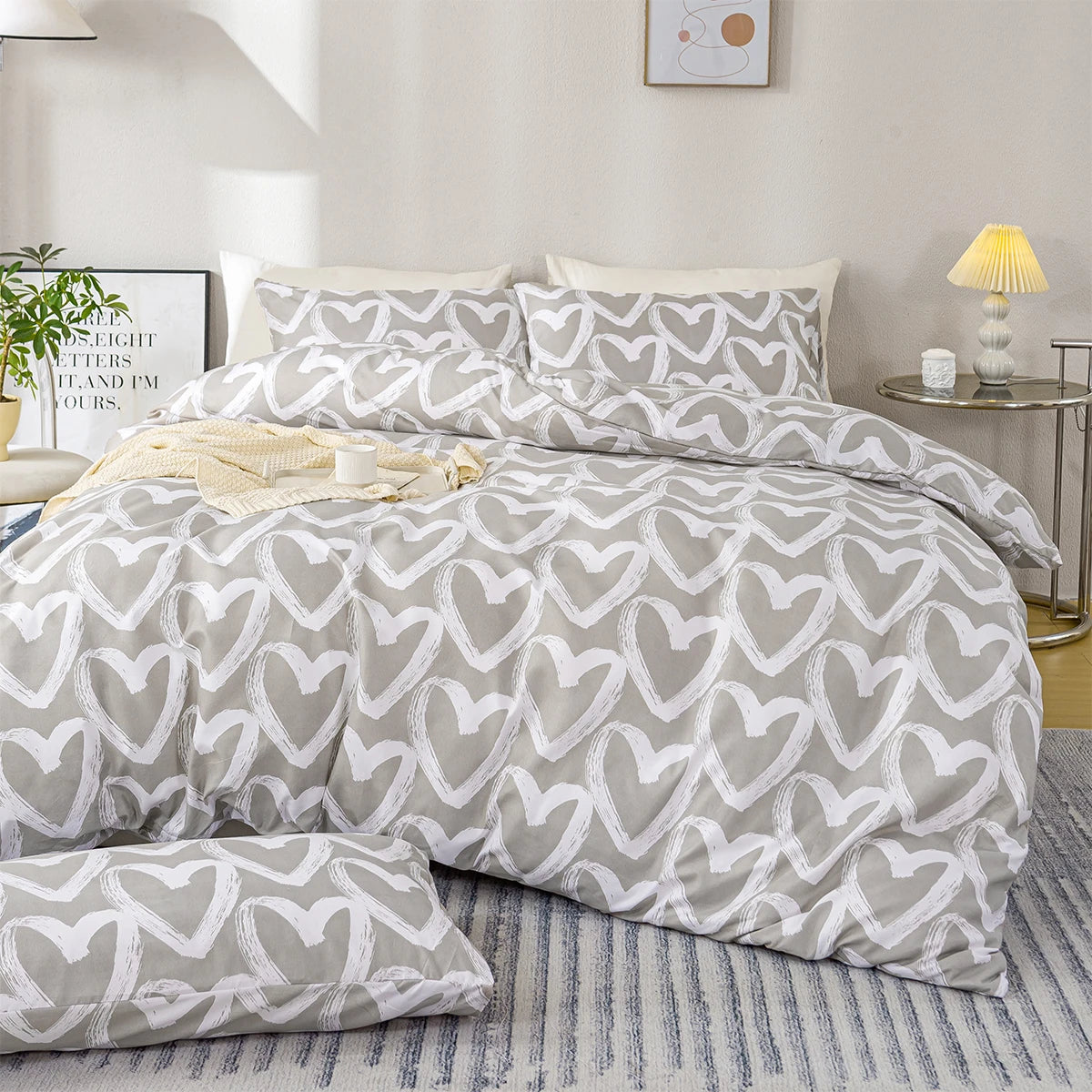 Gray and white heart-patterned bedding set on a bed in a bedroom.
