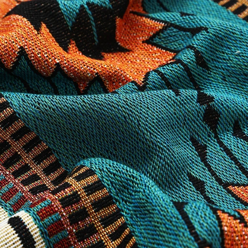 Close-up of a textured fabric with orange, black, and teal patterns.
