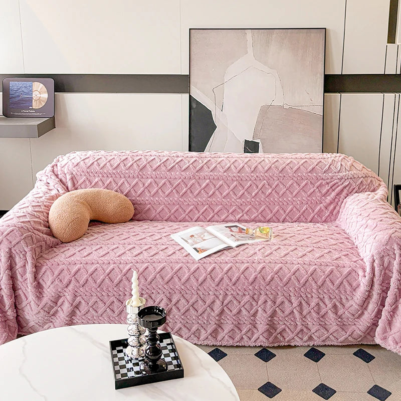 Pink textured sofa cover on a sofa with a decorative pillow and magazine in a living room setting.