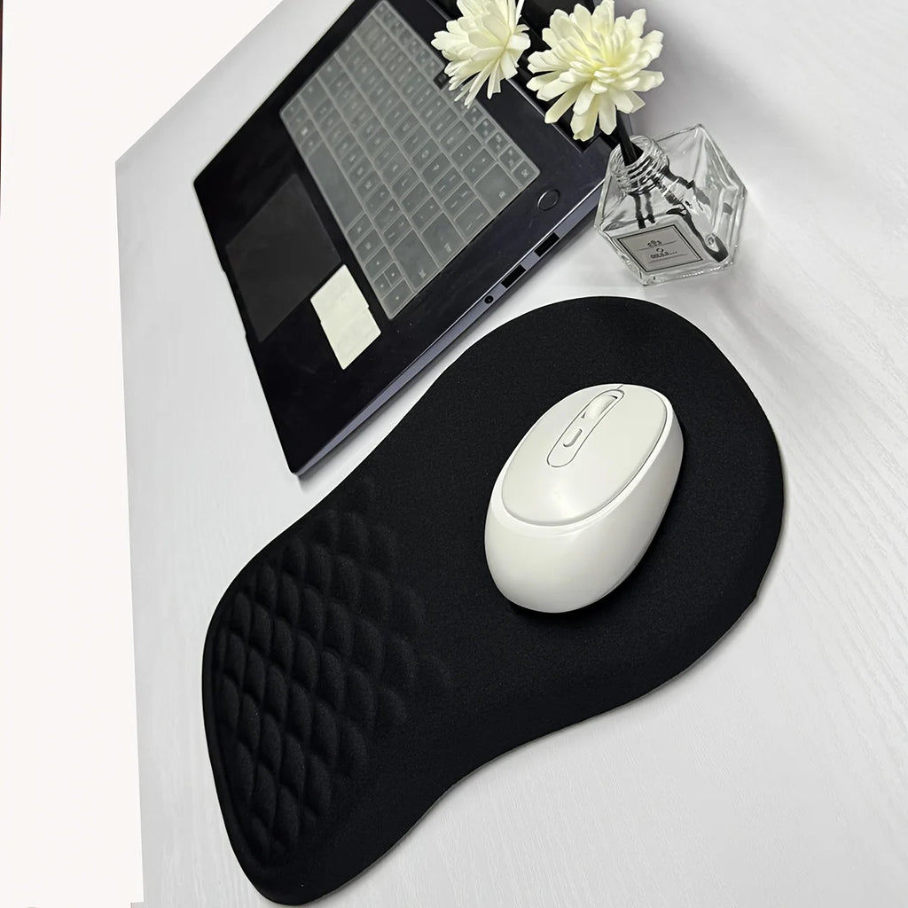 Black quilted mouse pad with a white mouse on a desk with a laptop and flowers.