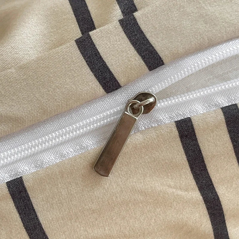 Close-up of a zipper on a duvet cover with a beige and black striped pattern