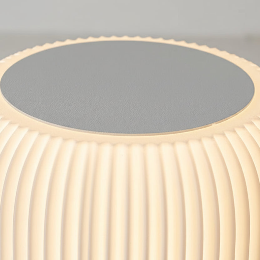 Close-up of the lamp’s top touch switch surface on a ribbed cream shade