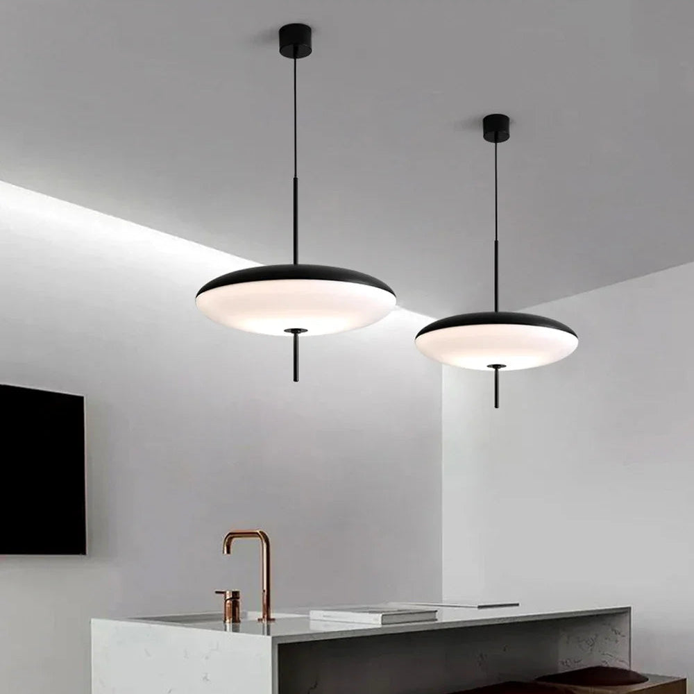 Modern kitchen with pendant lights, marble island, and wooden stools.