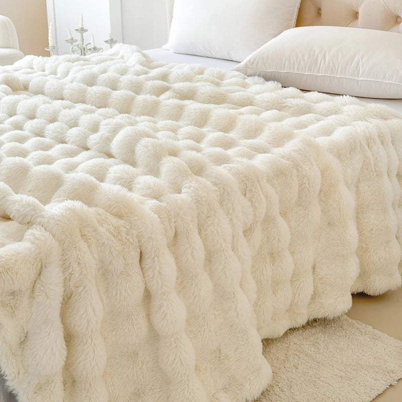 White fluffy blanket on a bed with pillows in a bedroom setting