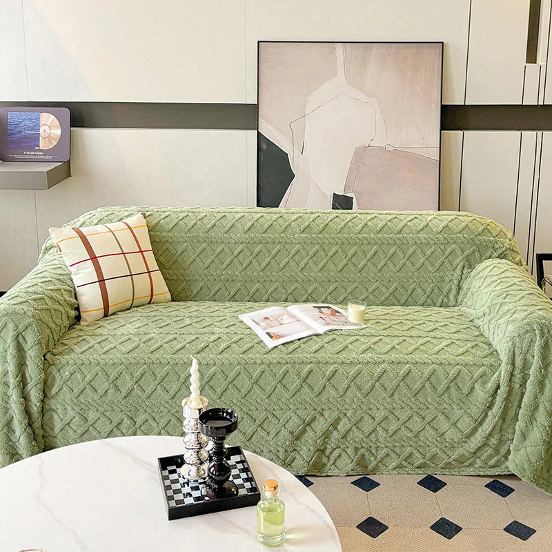 Green textured sofa with a decorative pillow and small table in a living room setting.