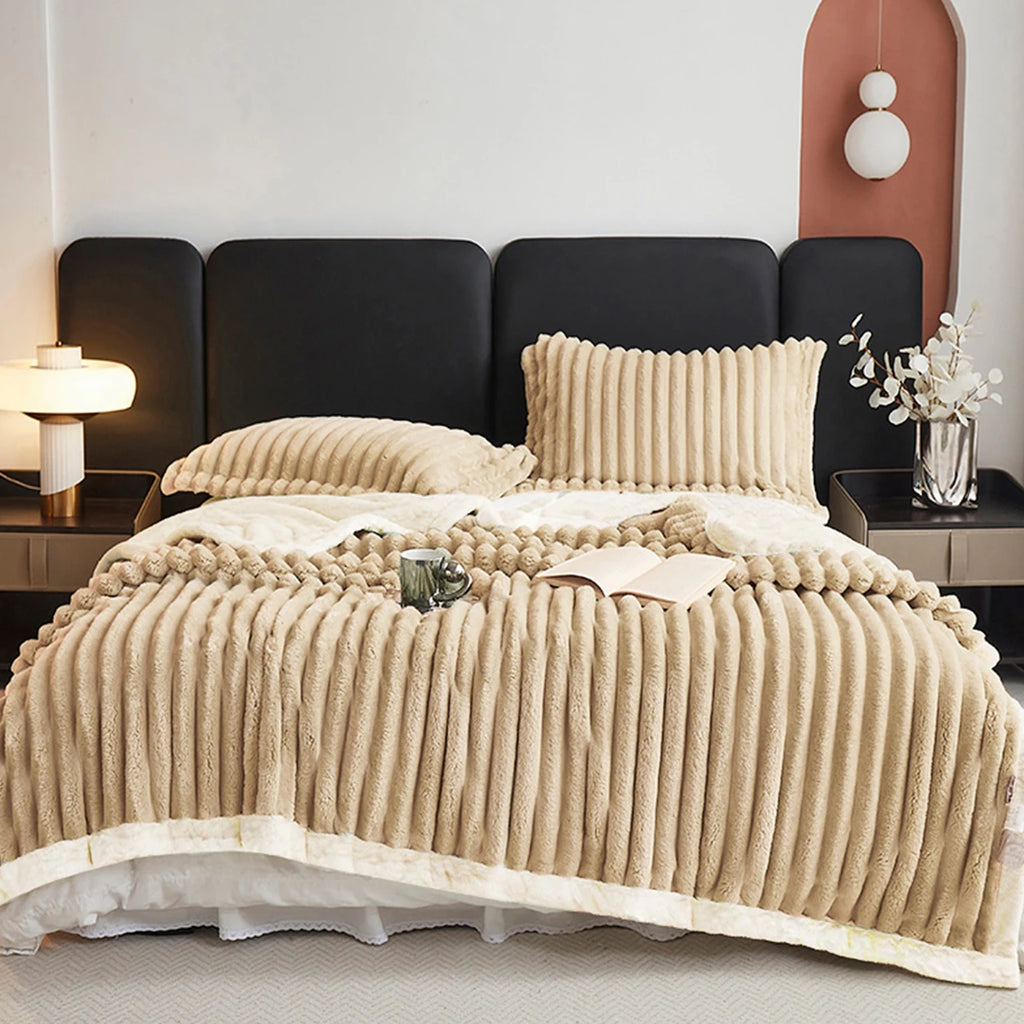 A warm beige textured blanket on a bed in a bedroom setting with a black headboard.