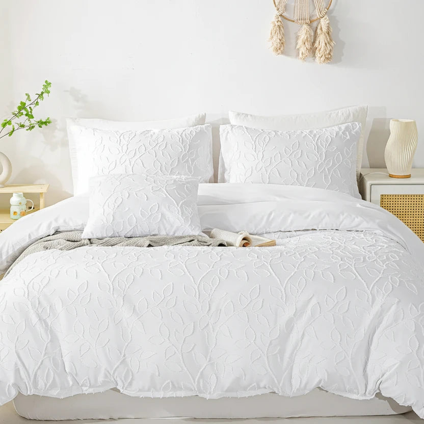 White textured bedding set on a bed with decorative elements in the background