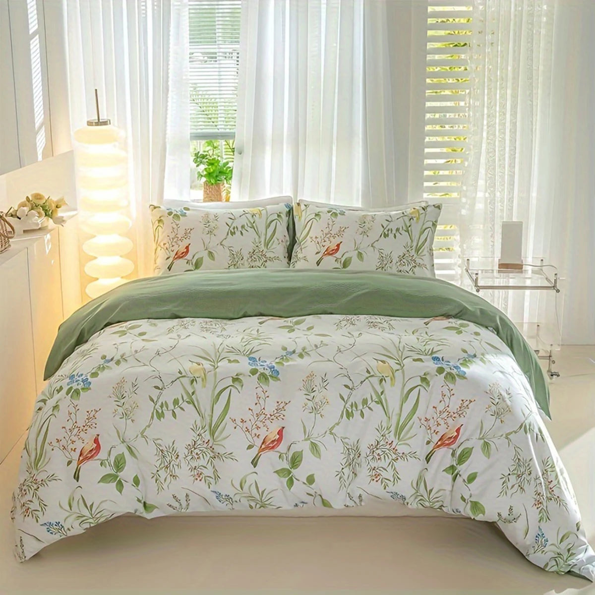 Floral and bird print duvet cover set with soft green reverse on a styled bed