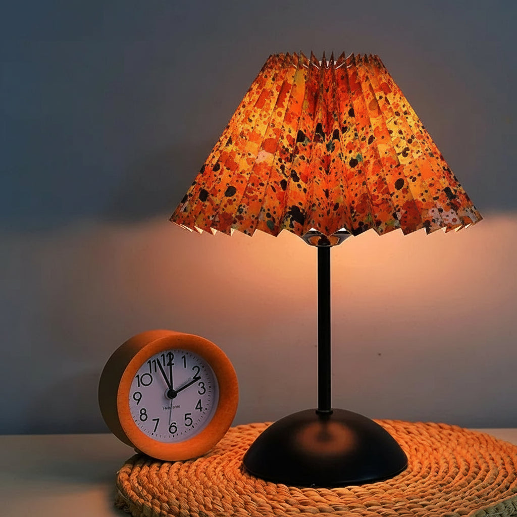 Floral-patterned lamp with a clock on a textured surface, against a dark background.