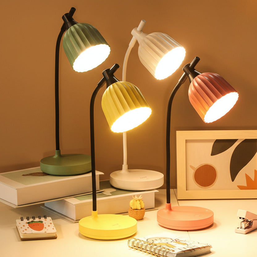 Set of colourful desk lamps on a desk with books and stationery.