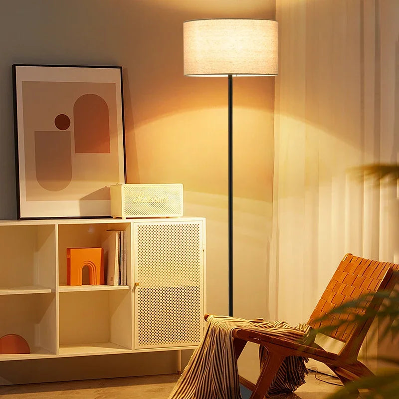 Full view of the minimalist Black Floor Lamp with a lit beige fabric shade.