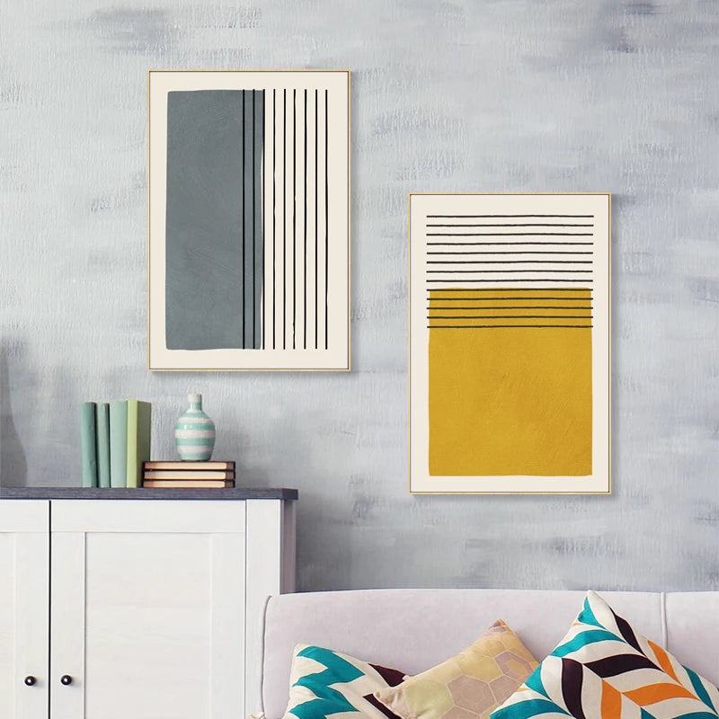 Two abstract art pieces on a wall with a sofa and cabinet below.